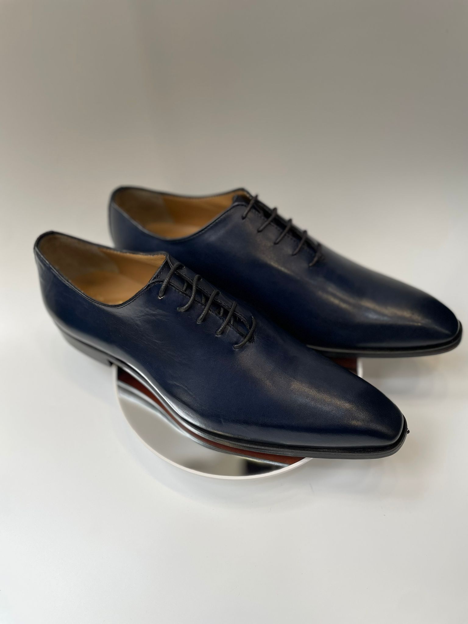 Chaussure Richelieu "One-Cut" en cuir lisse bleu nuit avec laçage fermé, vue de trois-quarts sur fond blanc.