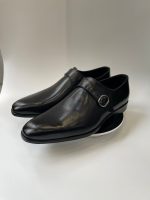 Chaussure Monk Strap en cuir noir pour homme avec boucle argentée, vue de profil sur fond blanc, style élégant et formel.