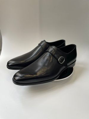 Chaussure Monk Strap en cuir noir pour homme avec boucle argentée, vue de profil sur fond blanc, style élégant et formel.