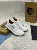 Sneakers blanches en cuir texturé effet crocodile avec lacets blancs et semelle crantée noire, présentées avec leur coffret Jespomi.