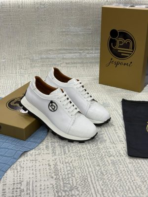Sneakers blanches en cuir texturé effet crocodile avec lacets blancs et semelle crantée noire, présentées avec leur coffret Jespomi.