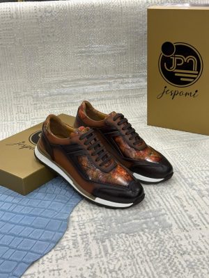 Sneakers homme en cuir marron patiné avec empiècements artistiques aux nuances cuivrées et semelle sportive blanche, présentées dans un écrin de marque Jespomi
